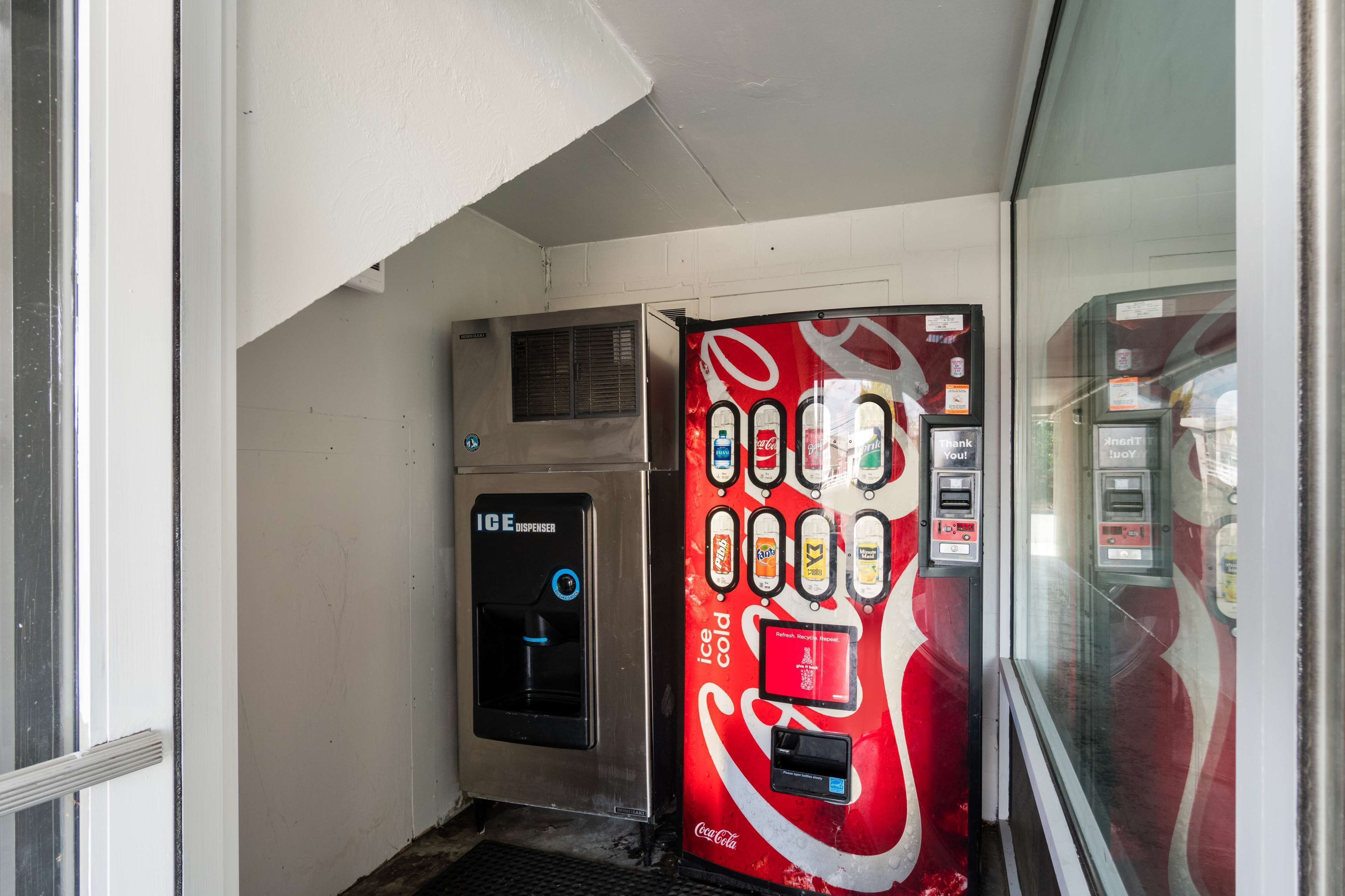 A vending machine with a Coca-Cola logo and an ice dispenser.