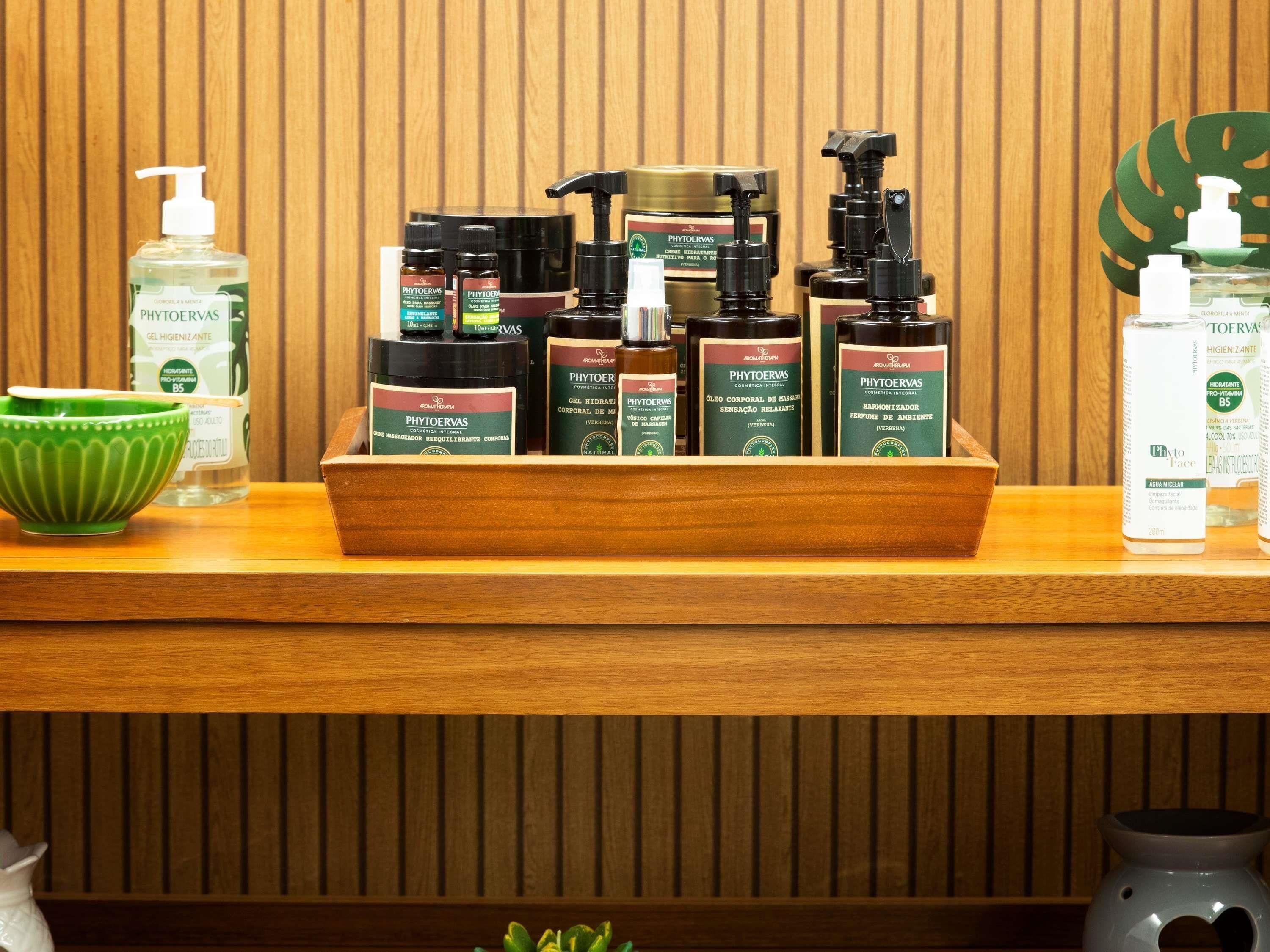 A wooden shelf with a variety of PHYTOERVAS products, including gels, creams, and a diffuser.