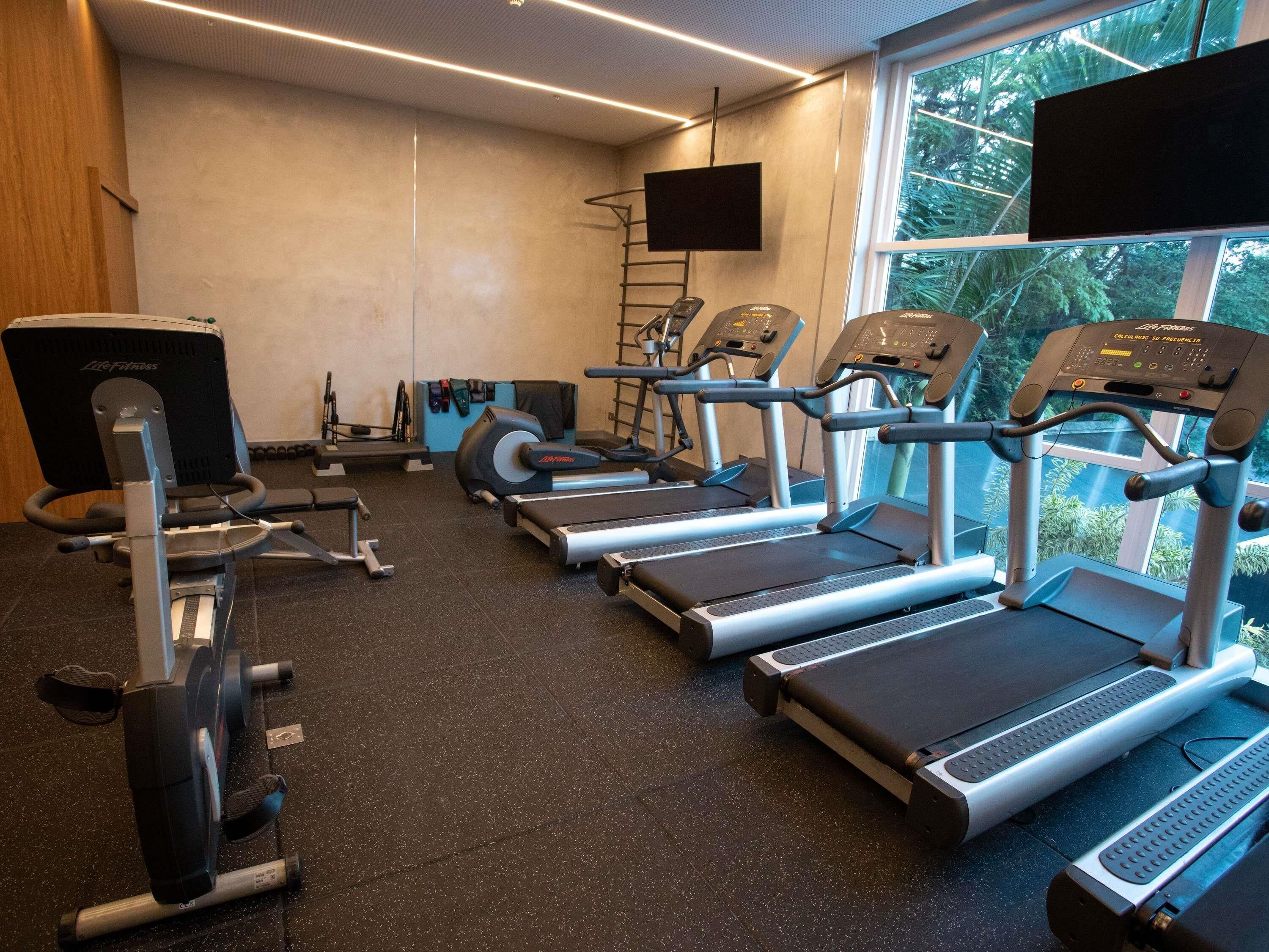 A gym with treadmills, a stationary bike, and a rowing machine.