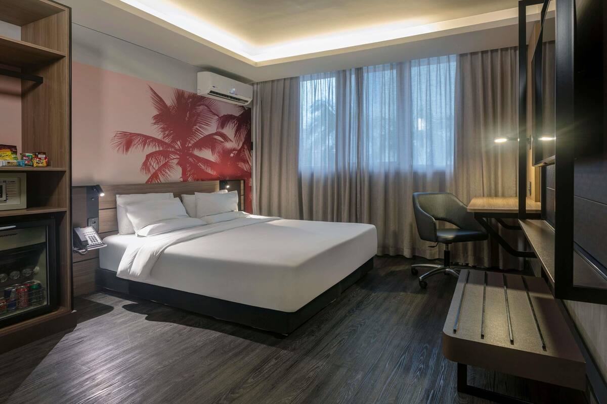 Een hotelkamer met een bed, bureau, stoel en televisie.