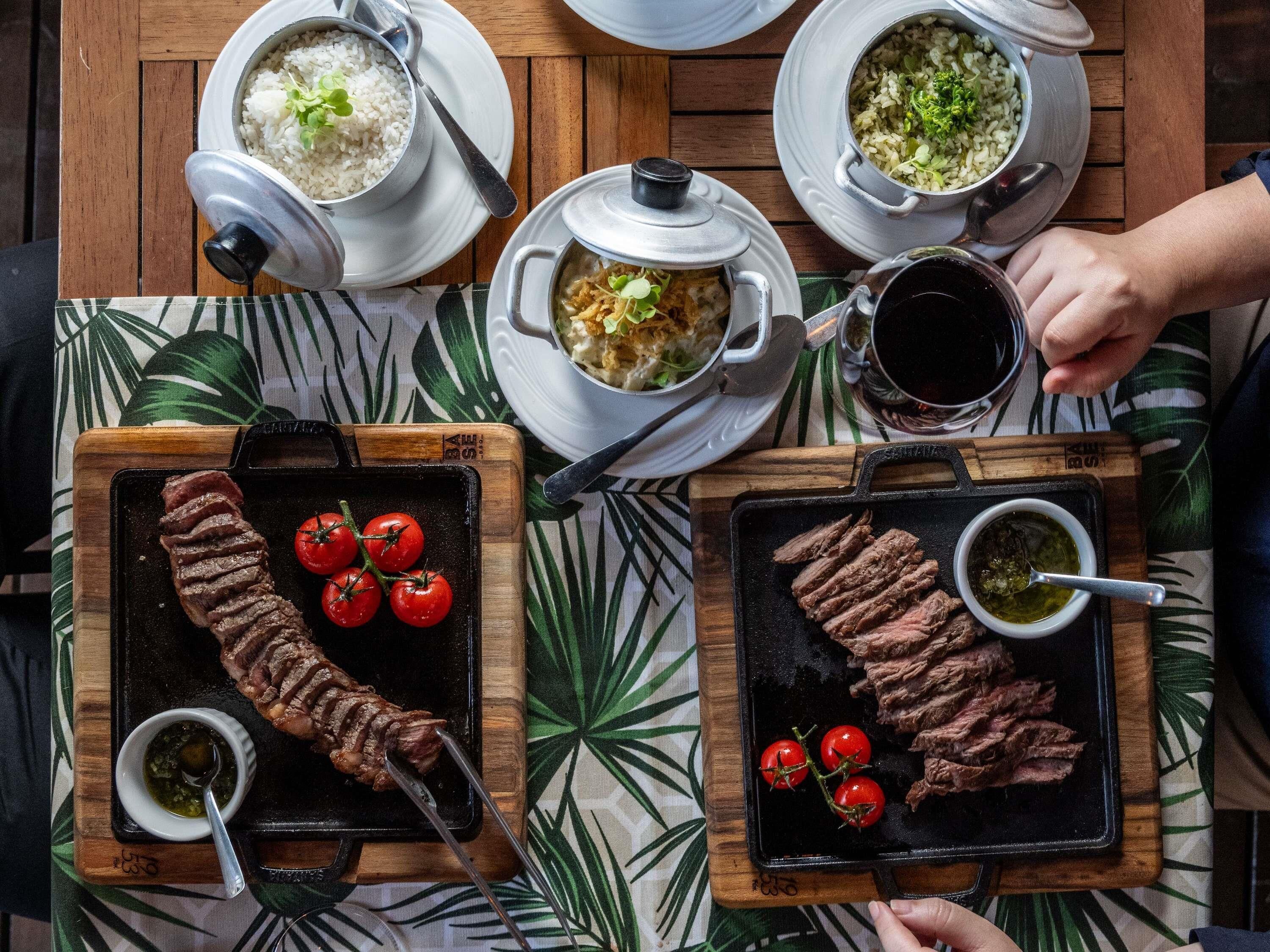 A dining table with various dishes, including rice, soup, and grilled meat, suggesting a meal setting.