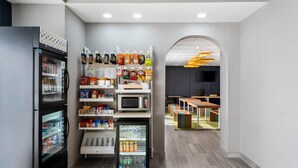 A modern interior with a refrigerator, microwave, and vending machines.