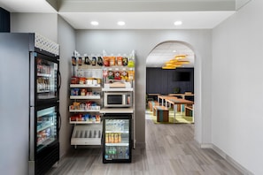 A modern interior with a refrigerator, microwave, and vending machines. - Spark by Hilton Staunton (Staunton)