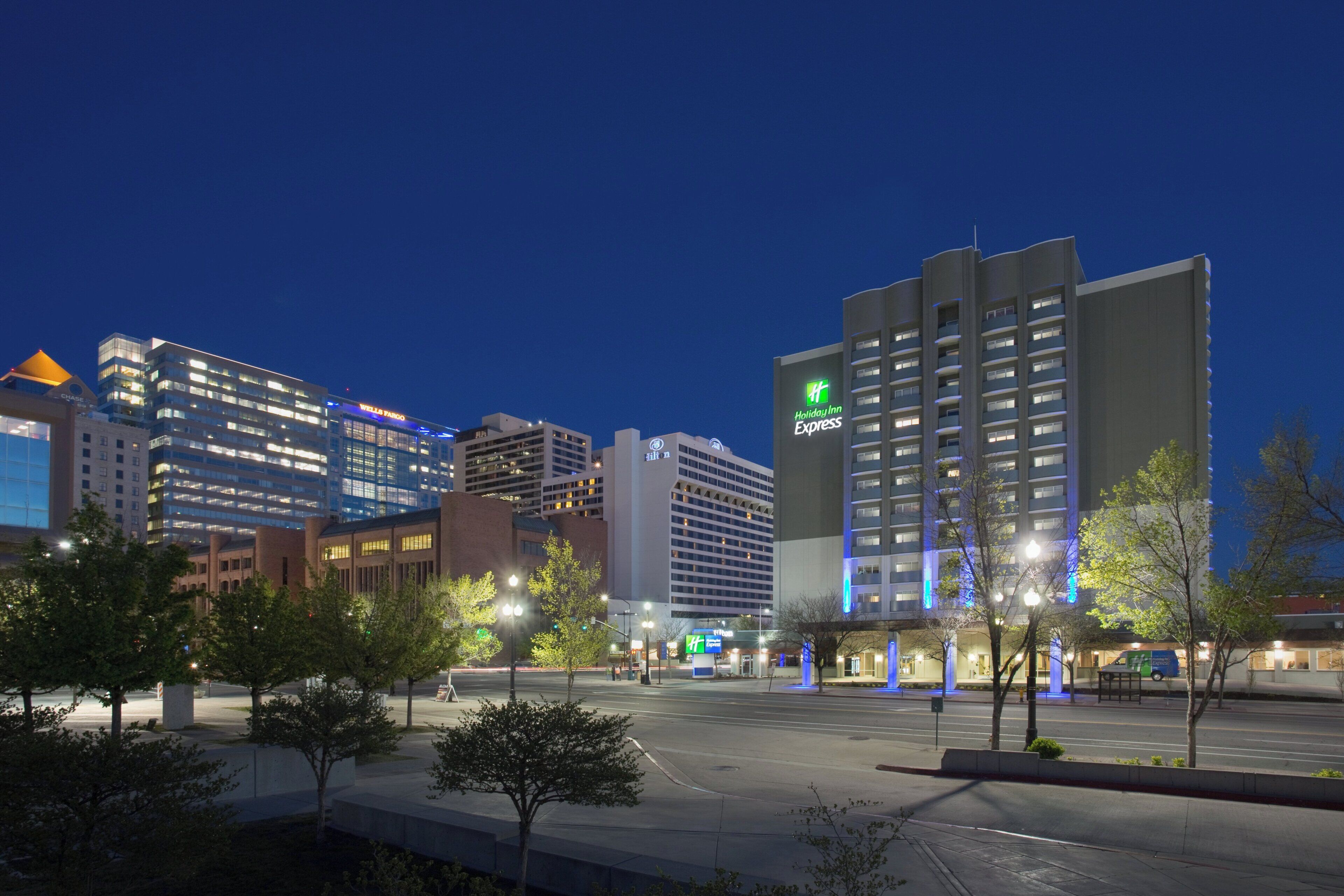 A hotel with a Holiday Inn Express sign, surrounded by other buildings and trees.