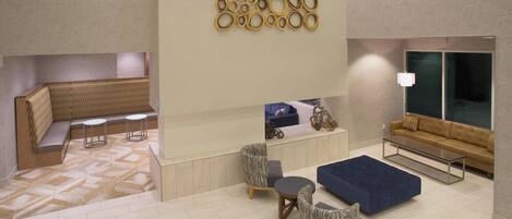 A modern lobby with a seating area, a reception desk, and a sofa.
