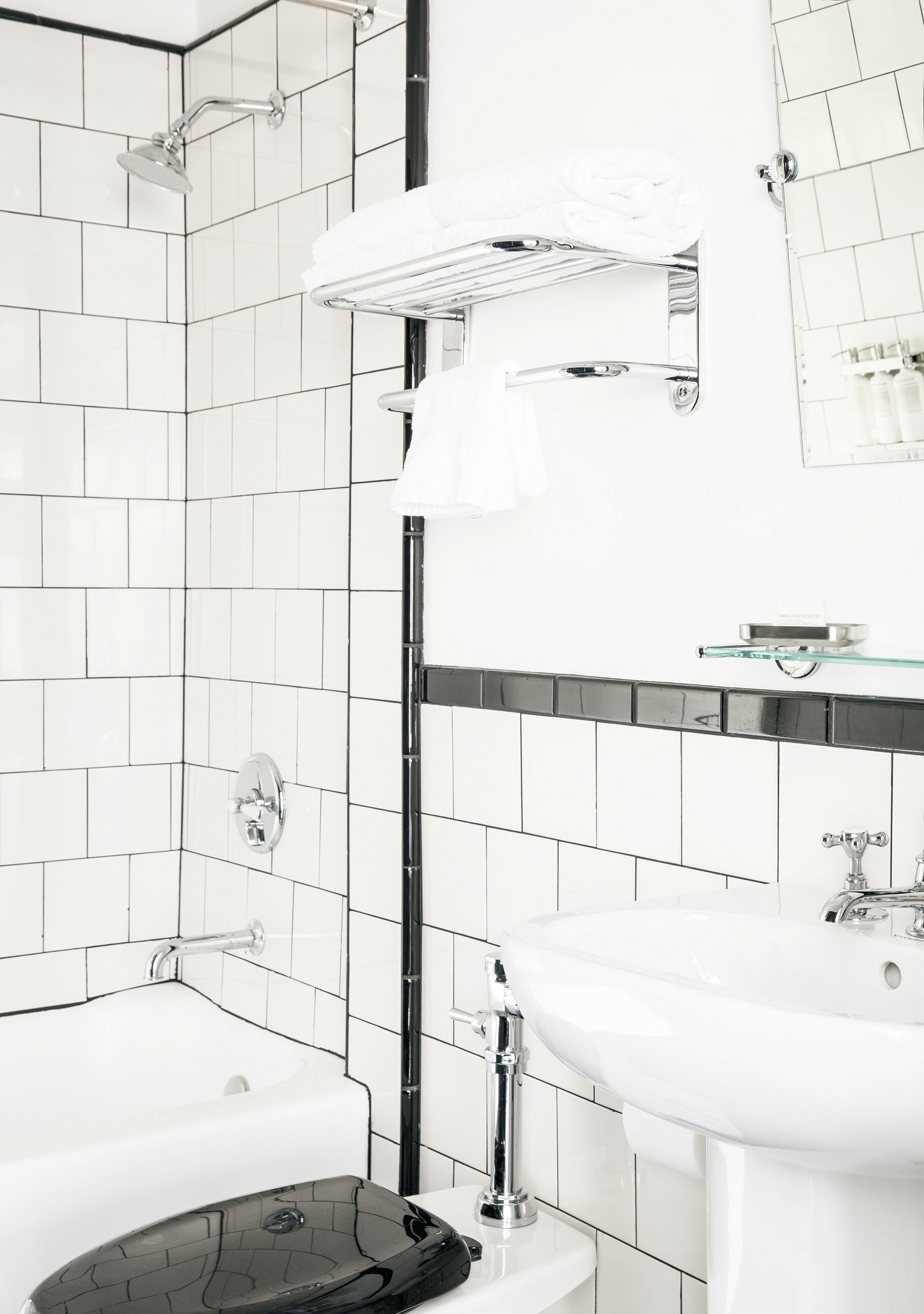 A modern bathroom with a bathtub, a sink, and a glass shelf above the sink.