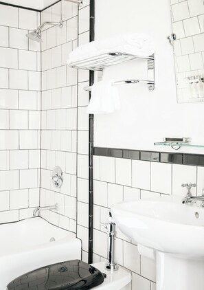 A modern bathroom with a bathtub, a sink, and a glass shelf above the sink. - Tilden Hotel (San Francisco)