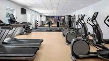 A gym with treadmills, elliptical machines, and weight equipment.