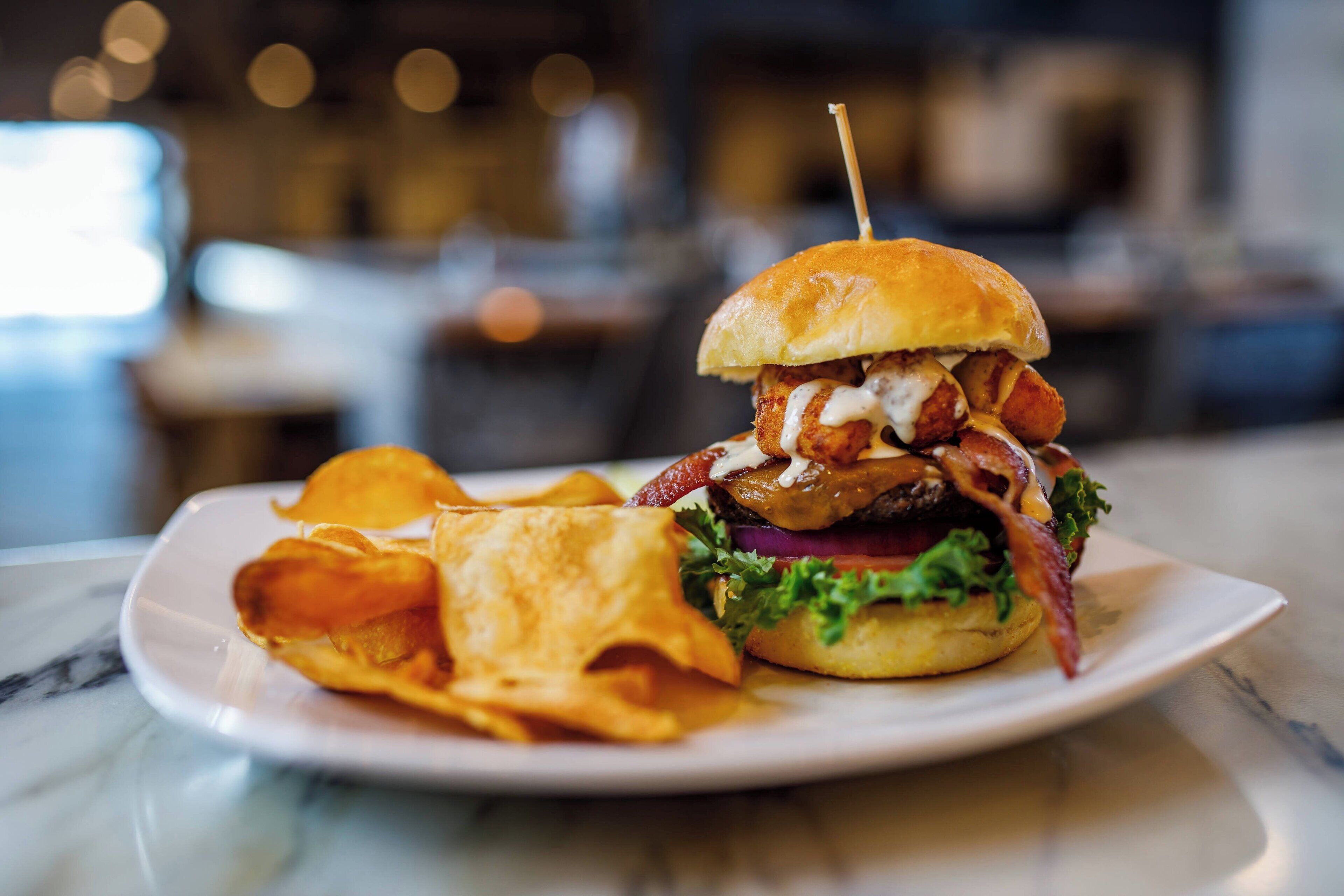 A plate with a burger, fries, and a drink.