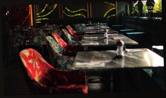 A restaurant interior with booths and tables, some with candles.
