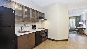 A modern kitchen with a refrigerator, stove, sink, and cabinets. - Candlewood Suites Grand Rapids Airport by IHG (Grand Rapids)