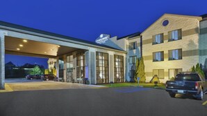 A hotel with a large entrance, a parking area, and a building with a sign that reads "CANDLEWOOD QUINTES". - Candlewood Suites Grand Rapids Airport by IHG (Grand Rapids)