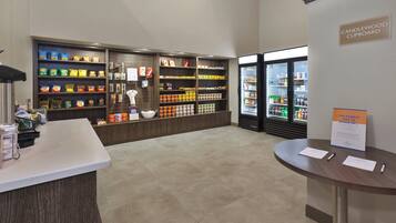 A snack and beverage area with shelves stocked with various snacks and a refrigerated display case.