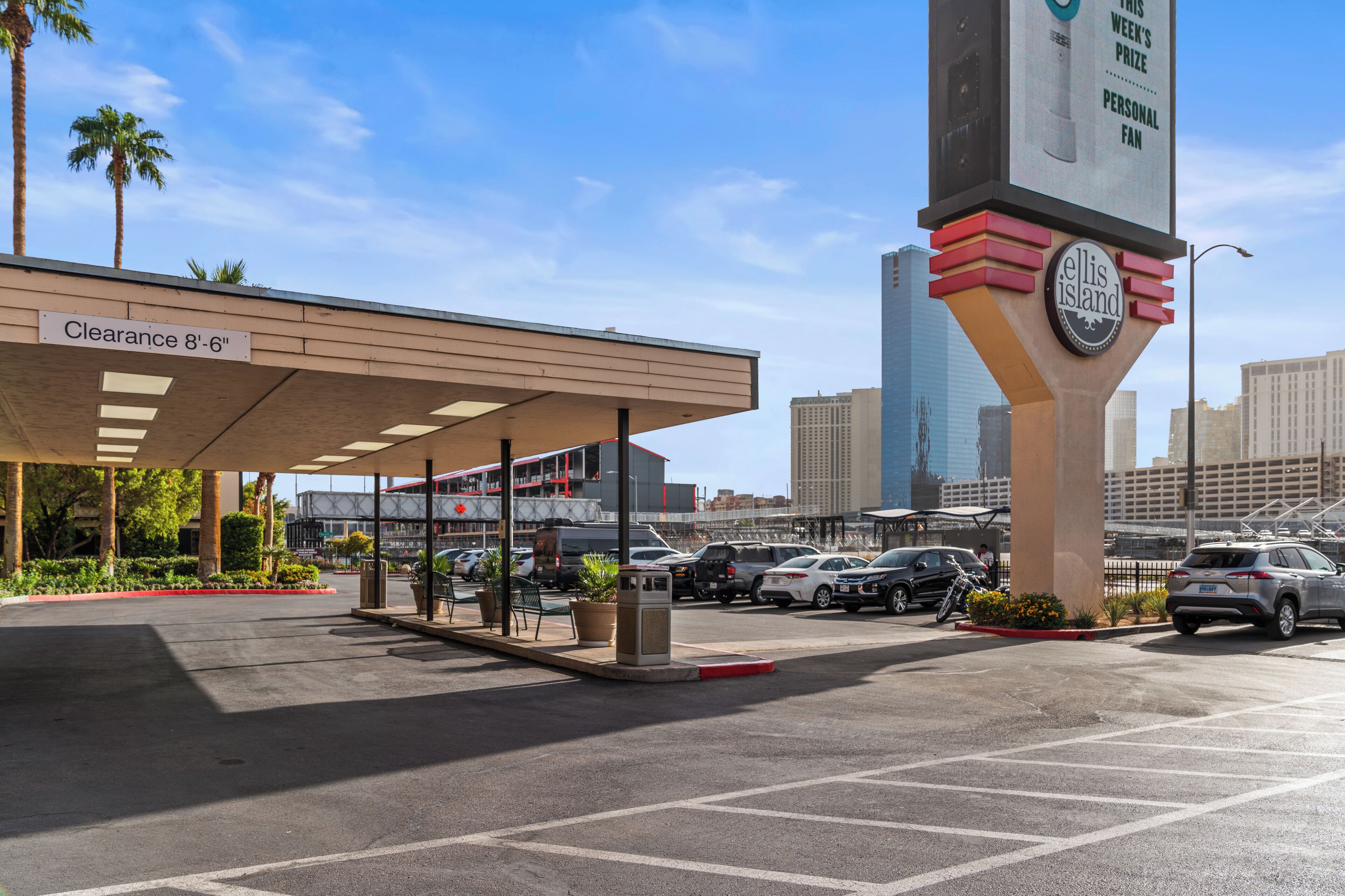 A gas station with a canopy, a clear height clearance sign, and a prominent Ellis Island sign.