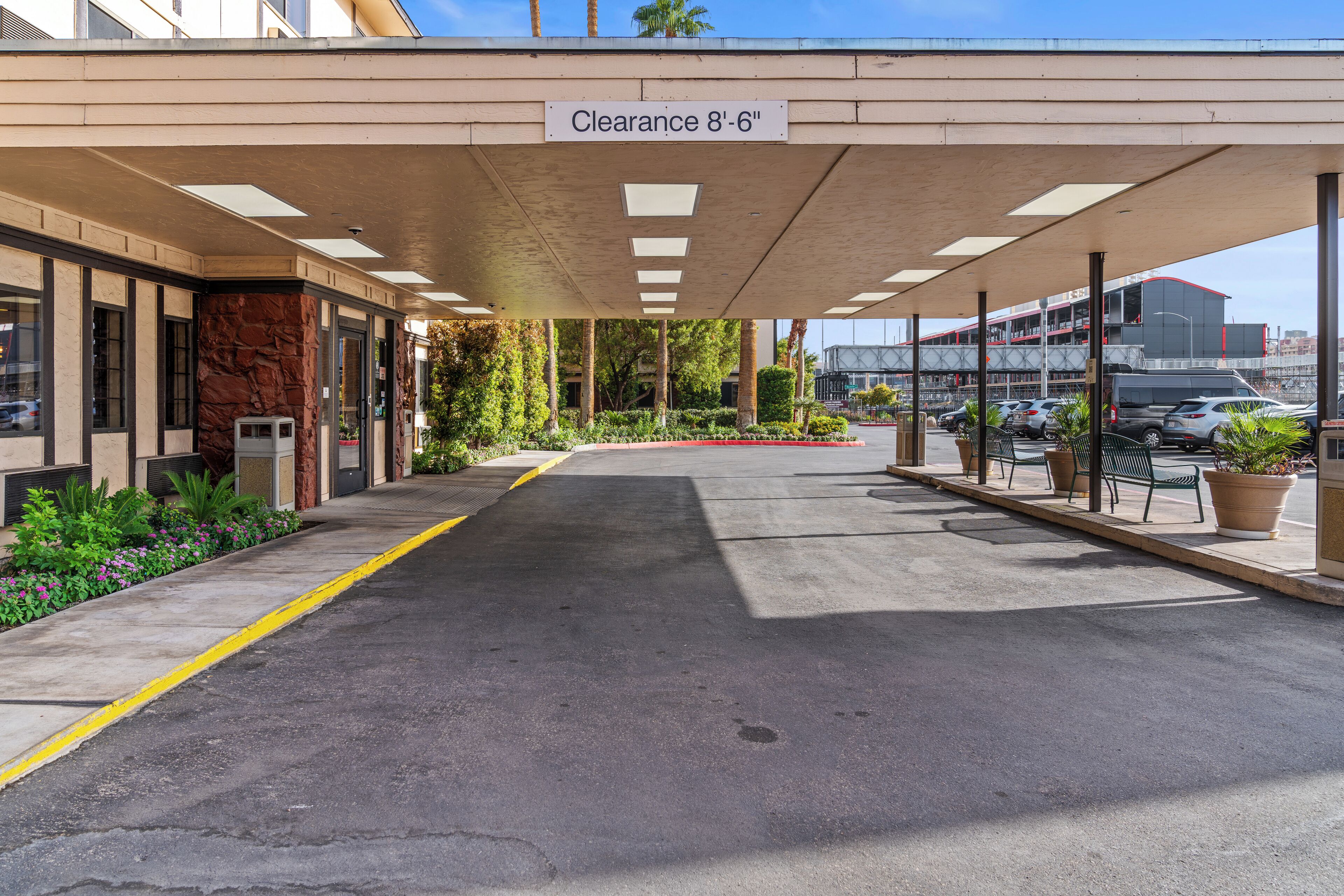 A covered parking area with a sign indicating a clearance of 8'-6".