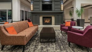 Una sala de estar moderna con chimenea, un sofá, sillones y una mesa de centro.