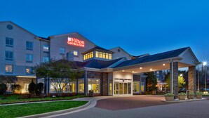 Un Hilton Garden Inn con fachada iluminada, entrada techada y diseño moderno.