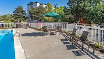 Una piscina al aire libre de temporada, sillones reclinables de piscina