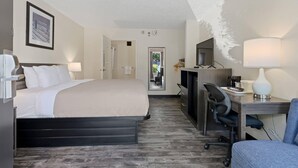 A hotel room with a bed, desk, chair, and a television. - Quality Inn Duluth - Atlanta Northeast (Duluth)