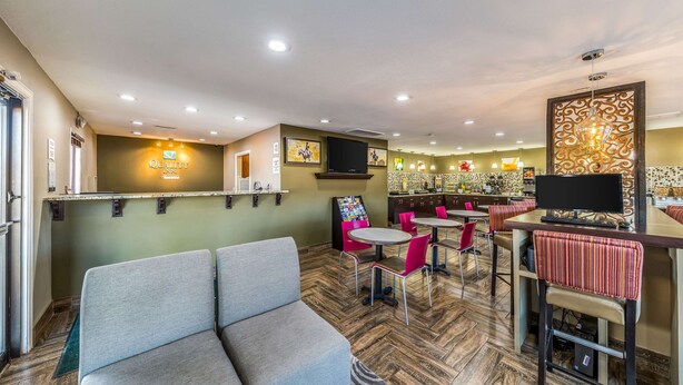 A hotel lobby with a reception desk, seating area, and a bar. - Quality Inn Glenpool - Tulsa (Glenpool)