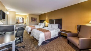 A hotel room with two beds, a desk with a chair, a TV, and a small table. - Quality Inn Glenpool - Tulsa (Glenpool)