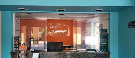 Una zona de recepción con una pared turquesa, un ventanal y un cartel que dice "Ward Johnson".