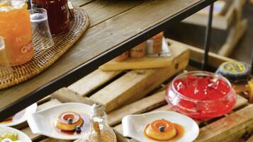 Un tavolo in legno con diversi piatti portoghesi, tra cui pasticcini alla crema e una bottiglia di salsa caramello.
