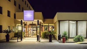 A hotel entrance with a sign reading "NOVOTEL HOTELS & RESORTS," a glass door entrance, and potted plants on the sidewalk. - Novotel Porto Gaia (Vila Nova de Gaia)