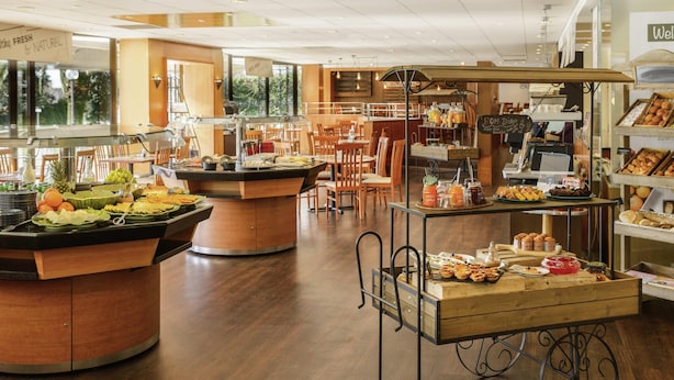 A buffet area with multiple serving stations, a coffee station, and a bakery display. - Novotel Porto Gaia (Vila Nova de Gaia)