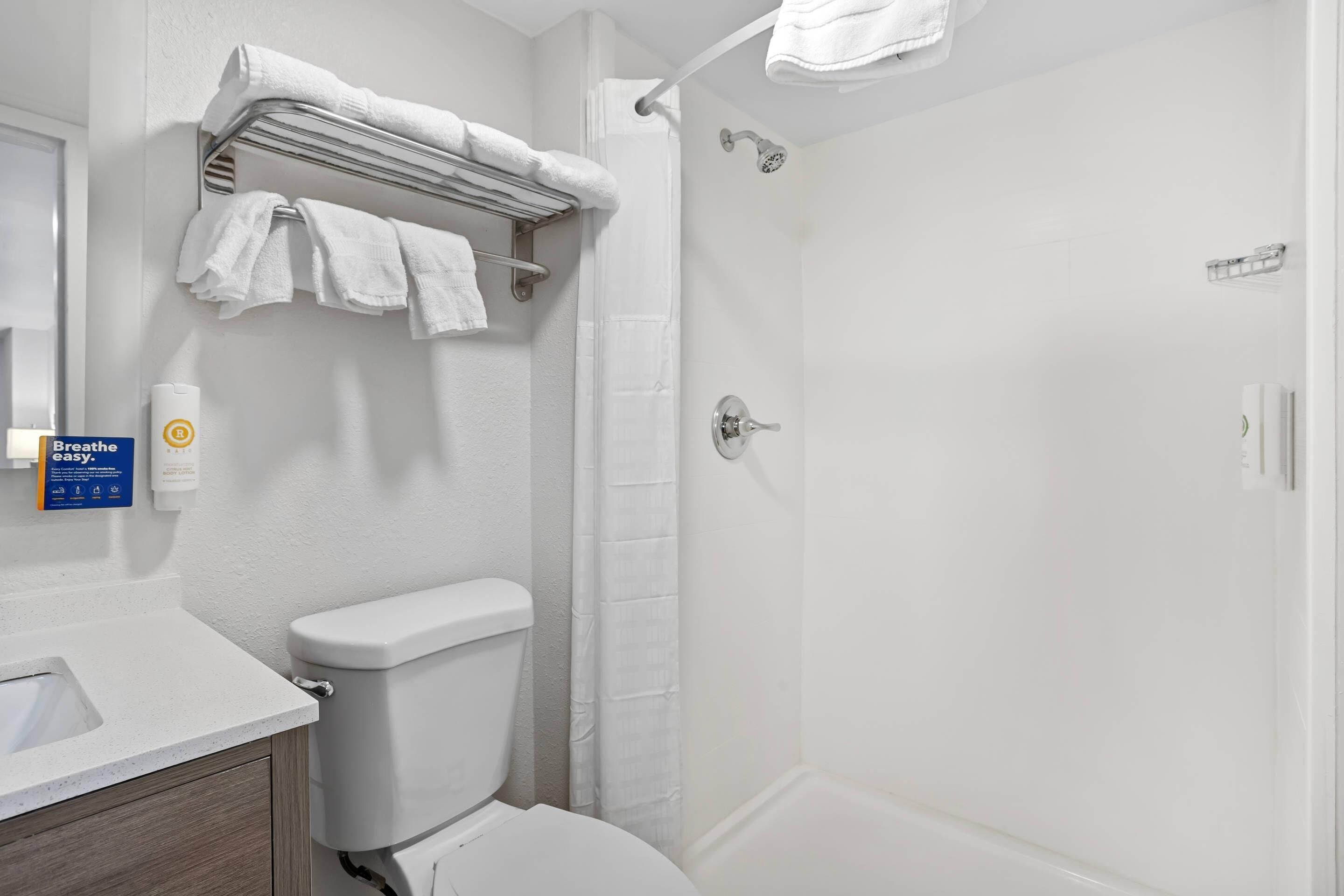 Une salle de bain équipée de toilettes, d’une douche et d’un porte-serviettes.
