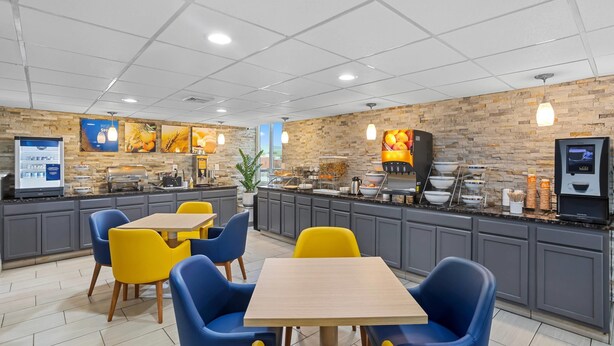 A modern restaurant with a counter, seating area, and kitchen. - Comfort Inn Dunmore - Scranton East (Scranton)