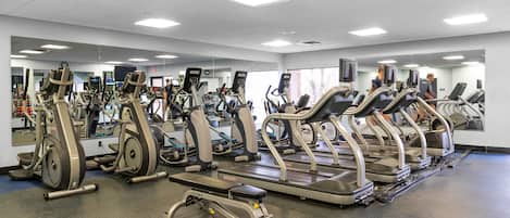 A gym with multiple treadmills, ellipticals, and weight machines.