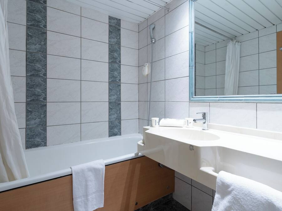 Une salle de bain moderne avec une baignoire, un lavabo et un miroir.
