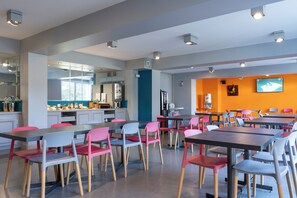 Enjoy meals in this spacious dining area with tables, chairs, and a flat-screen TV.