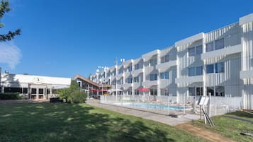 Un hôtel moderne doté d’une piscine, d’un espace extérieur aménagé et d’une pelouse bien entretenue.