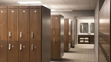 A hallway with wooden lockers numbered 37 to 43, a restroom with a sink and mirror, and a carpeted floor.