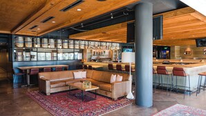 A spacious lounge area with a leather sofa, a coffee table, and a bar area with stools.