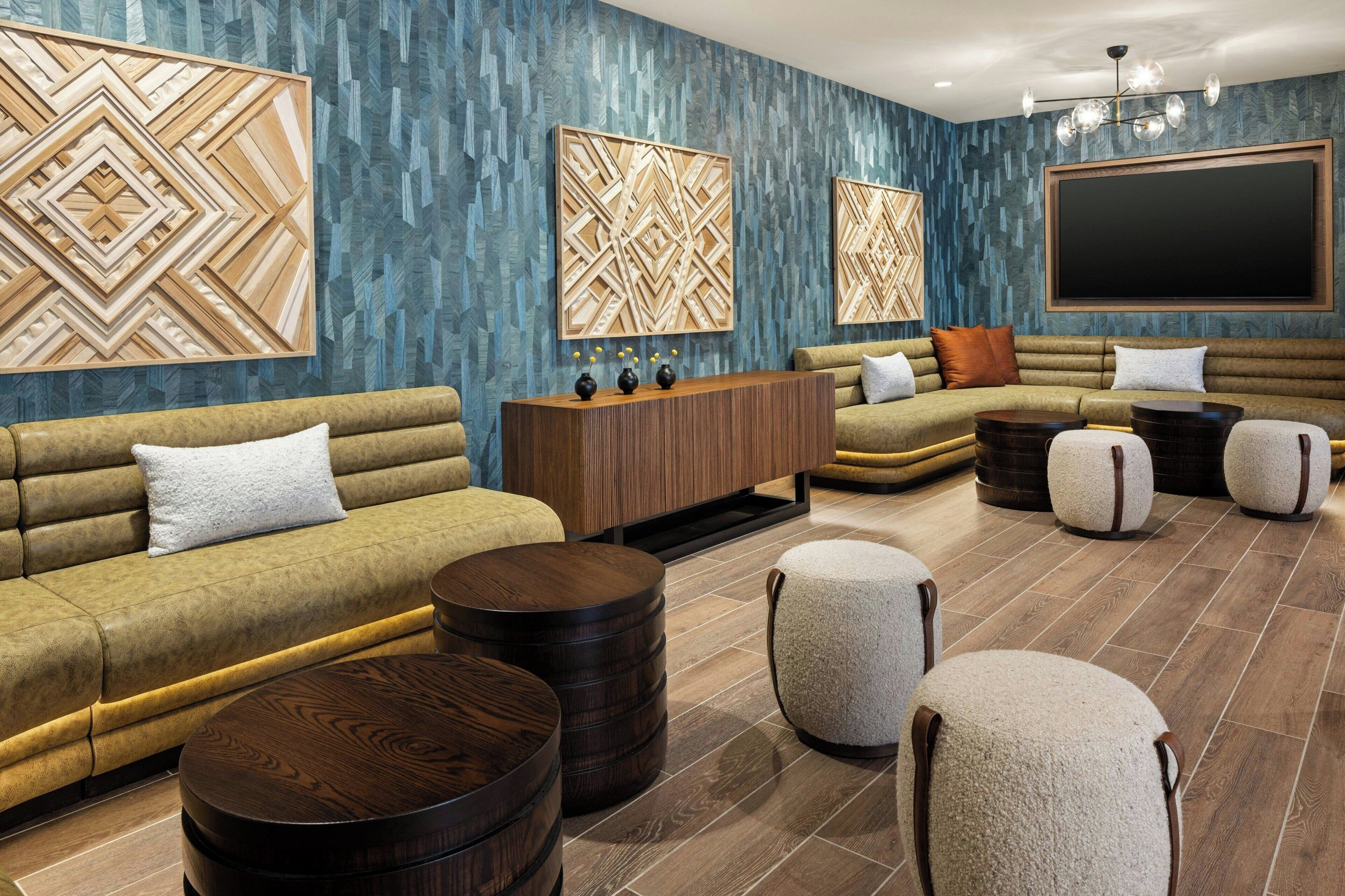 A modern living room with a sectional sofa, round coffee tables, and decorative wall panels.