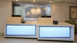 Modernilla designilla varustettu vastaanottotiski, jossa on lasisein ä ja kaksi tietokoneasemaa.
