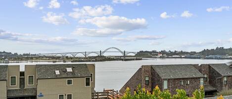 A view of a bridge over water, buildings with sloped roofs, and a clear sky.