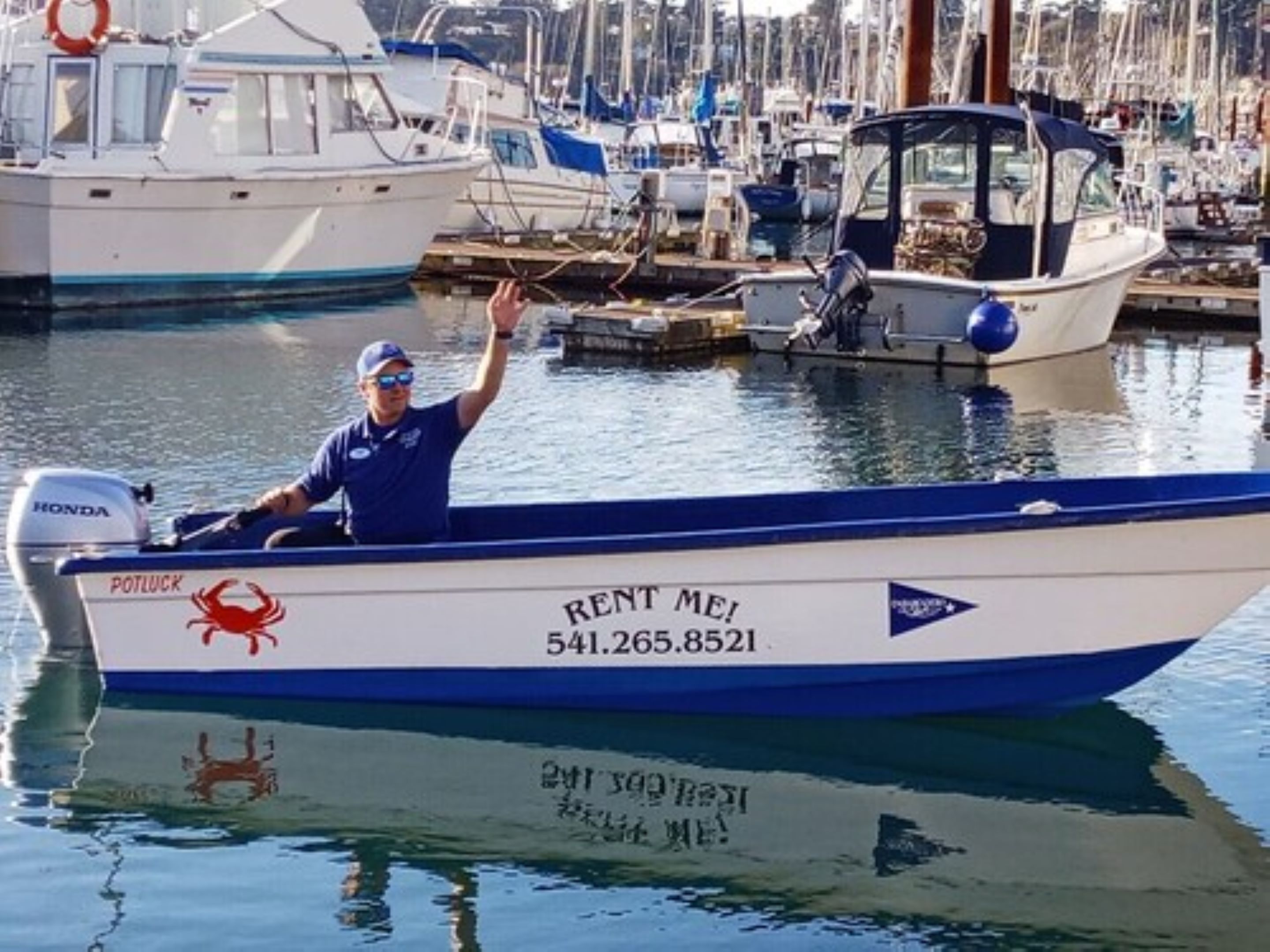 A boat with "RENT ME!" and a phone number on the side.