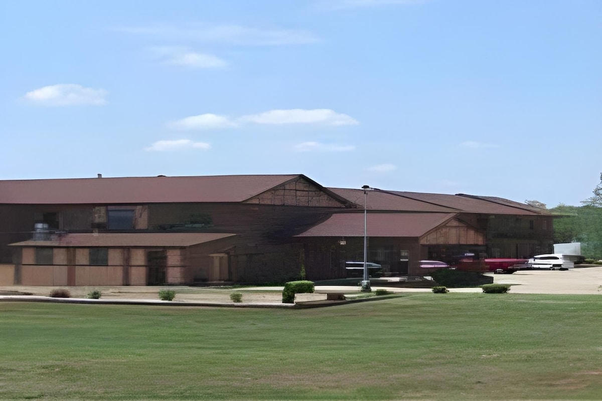 A two-story building with a flat roof and a covered front porch.