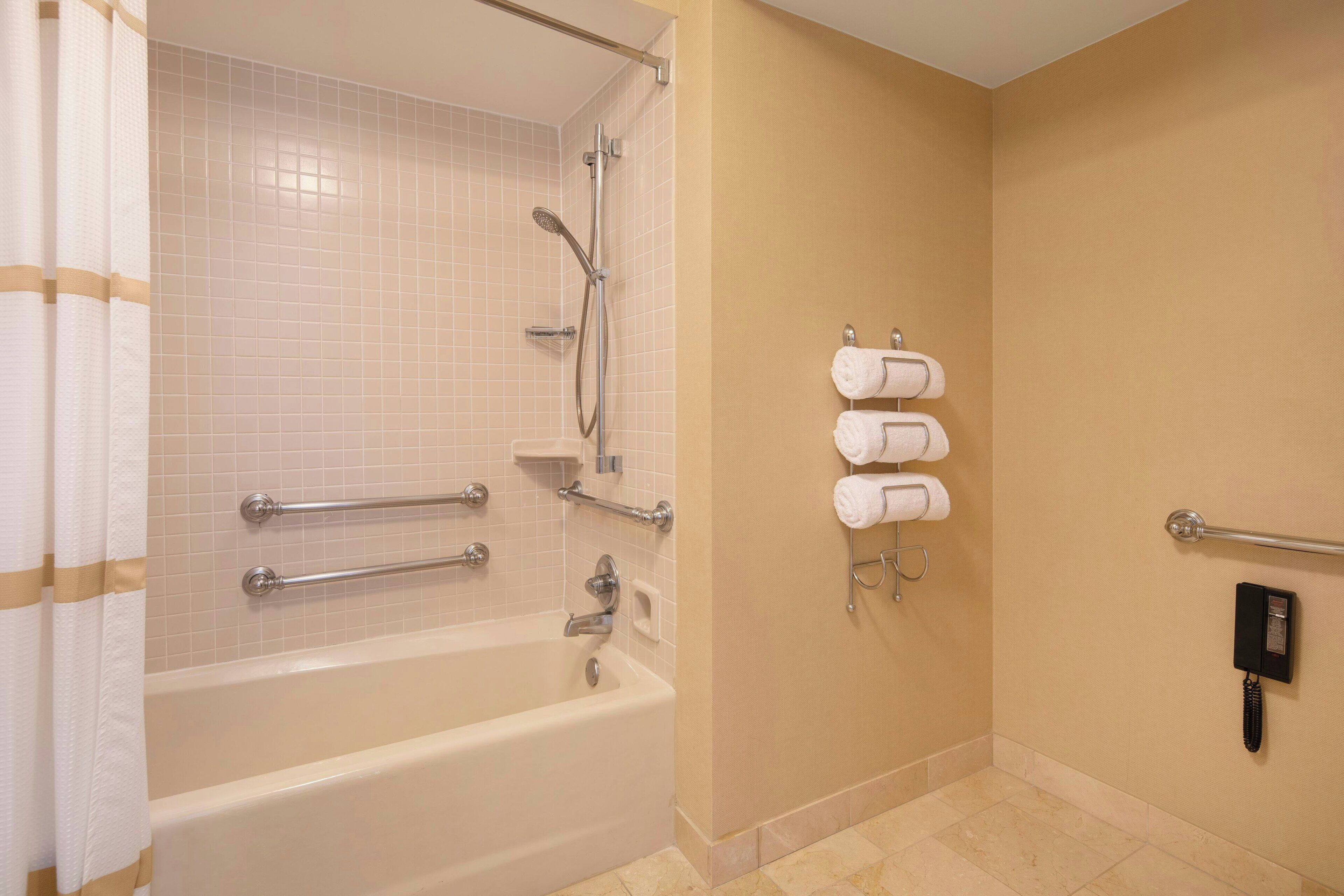Un baño con bañera, ducha y secador de manos.