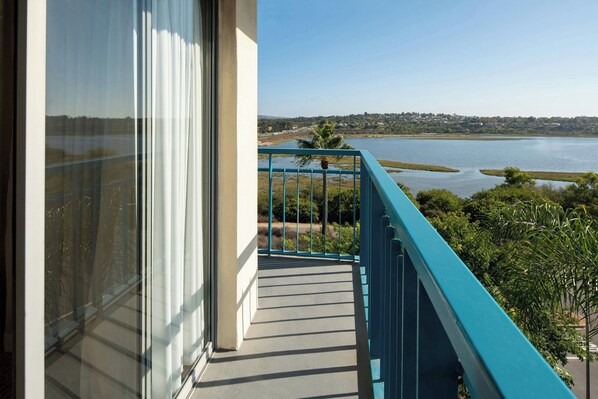 Un balcon donnant sur un lac et sur des bâtiments situés au loin.