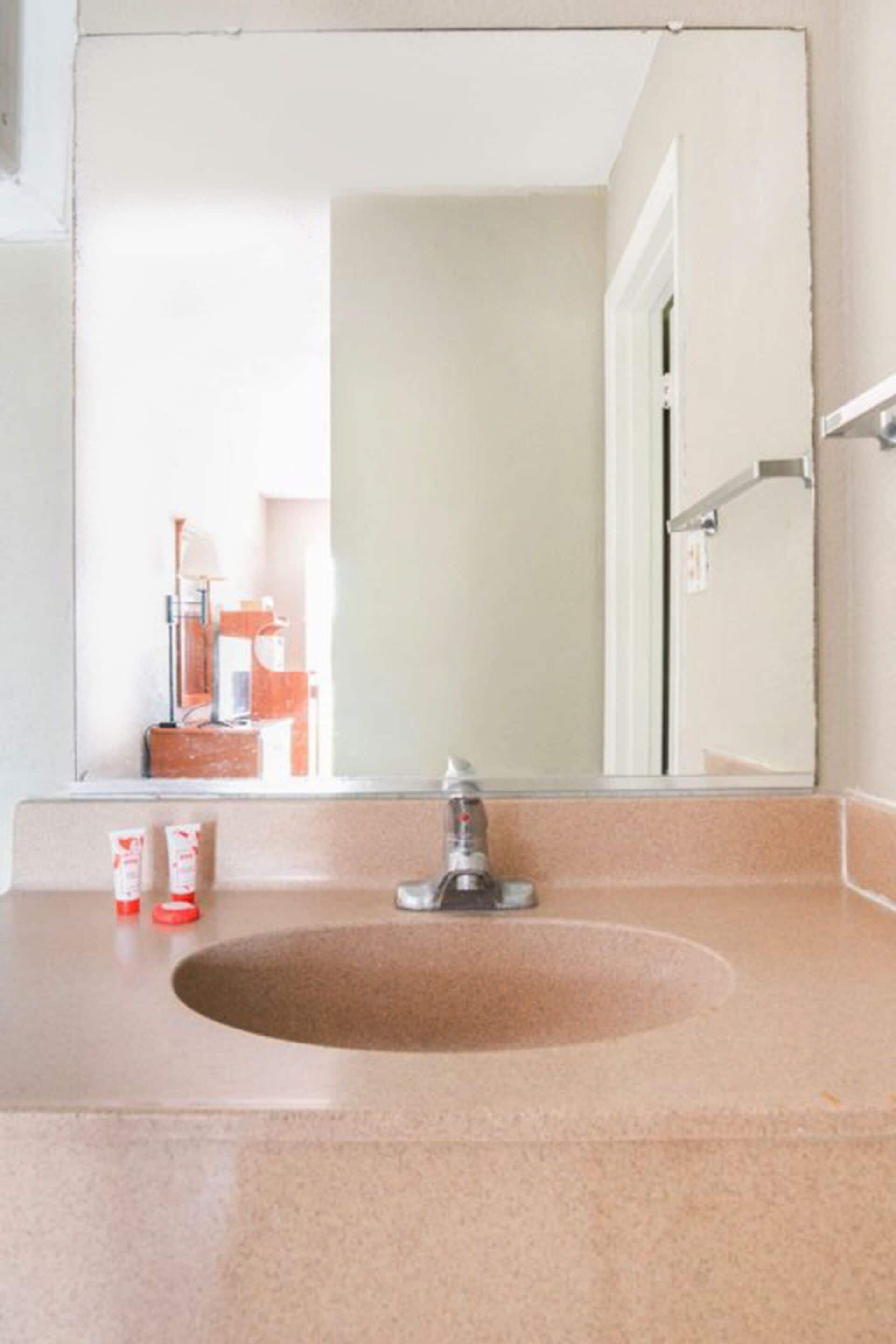 Une salle de bain équipée d’un lavabo, d’un miroir et d’un porte-serviettes.