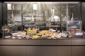 A buffet with various food items and utensils. - LUGANODANTE Boutique & Lifestyle Hotel (Lugano)