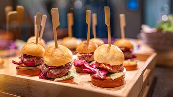 Un plateau en bois avec de petits hamburgers et des cure-dents.
