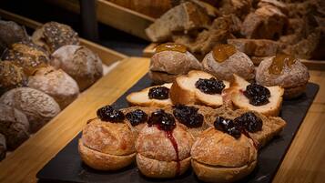A variety of pastries and bread on a wooden table.