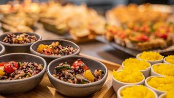 A variety of food dishes in bowls and plates, including salads and rice dishes.