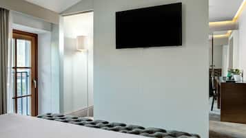 Habitación de hotel con una cama grande, un televisor de pantalla plana en la pared, una lámpara de noche y vistas al exterior a través de una ventana.